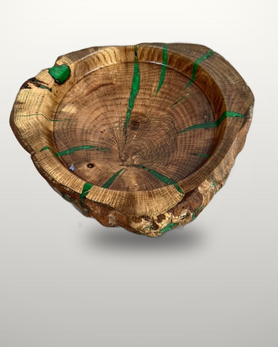 Live-edge oak bowl, the radial cracks filled with green resin, bark edge left on