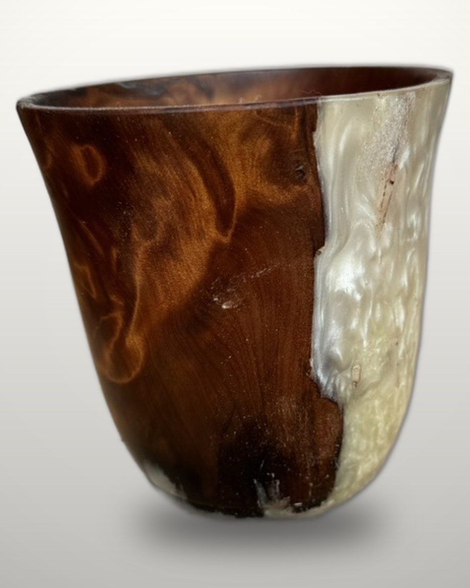 The same swamp kauri vessel turned to show the pearl-white resin face